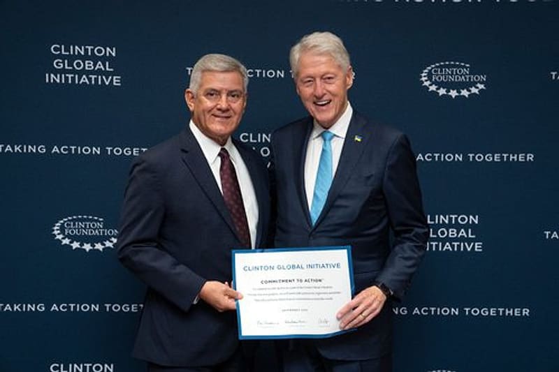 Clinton Global Initiative Commitment to Action certificate presentation with former U.S. President Bill Clinton